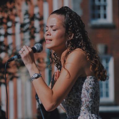 Eva singing into a mic at outdoors event